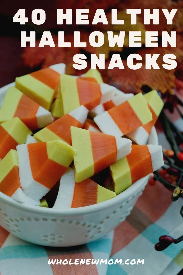 Plate of assorted healthy Halloween treats like pumpkin bites and fruit snacks.