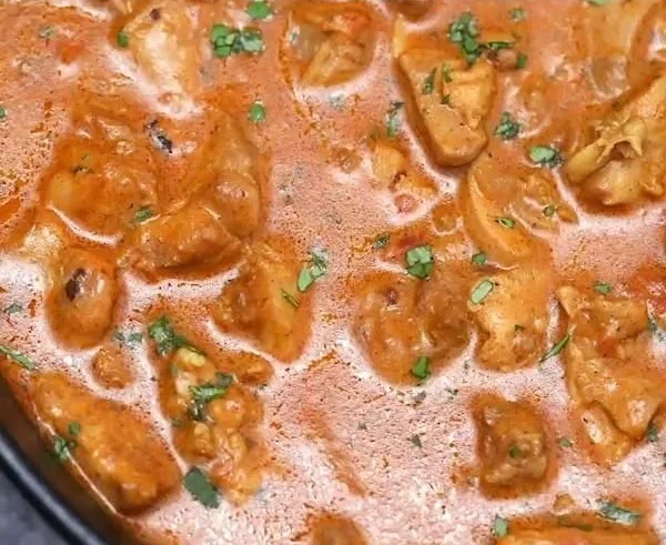 Homemade chicken tikka masala served in a bowl with rice and naan bread