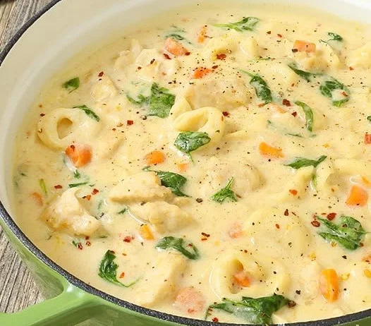 Bowl of creamy Chicken Alfredo Tortellini Soup garnished with parsley