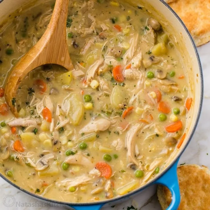 Bowl of creamy Chicken Pot Pie Soup topped with herbs and vegetables