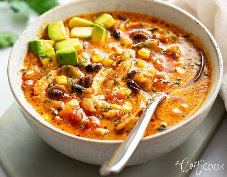 Bowl of hearty chicken taco soup garnished with cilantro and lime