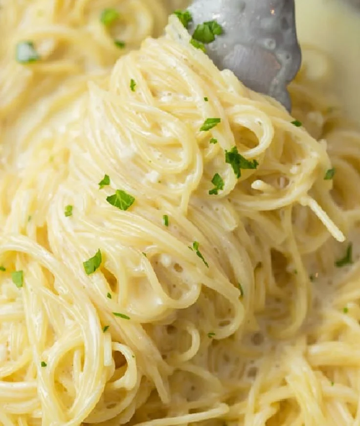 Creamy garlic parmesan pasta in a bowl with fresh herbs and grated cheese