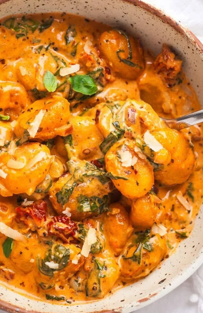 Creamy sundried tomato dish garnished with fresh herbs