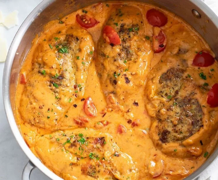 Creamy tomato chicken dish garnished with fresh herbs and served on a plate