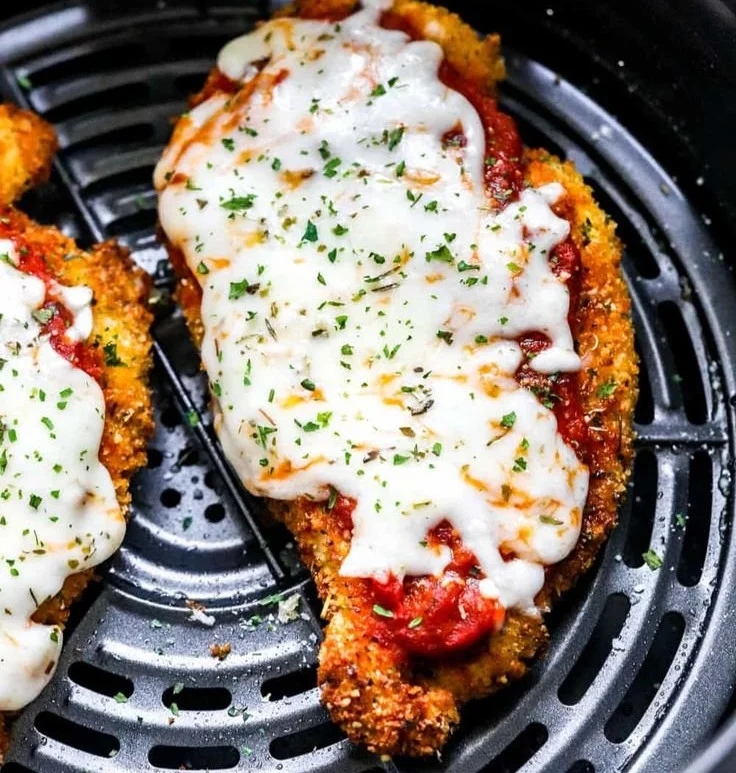 Crispy healthy chicken parmesan served with fresh herbs and marinara sauce