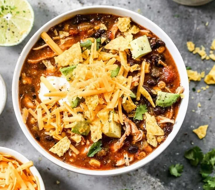 Bowl of low-calorie chicken enchilada soup made in a crockpot