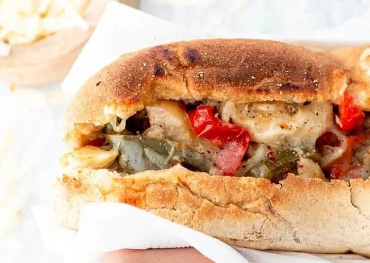 Delicious Crockpot chicken Philly cheesesteak served with peppers and onions
