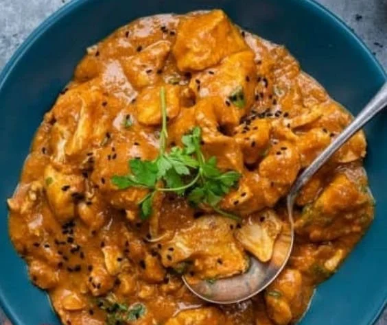 Delicious slow cooker chicken curry served in a bowl, garnished with herbs.