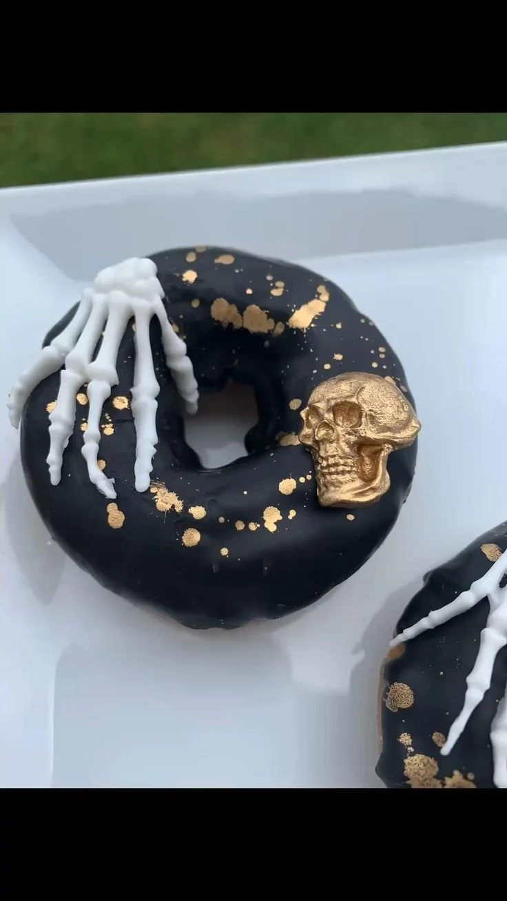 Halloween themed pumpkin donuts decorated with frosting and sprinkles