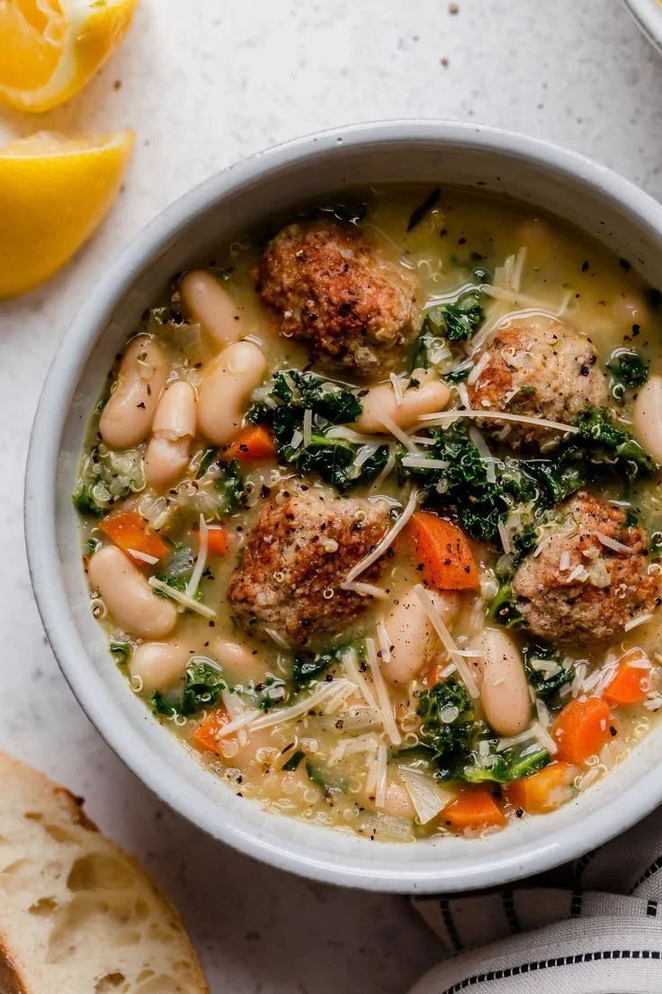 Bowl of Italian Wedding Soup with Turkey Meatballs, garnished with fresh herbs.