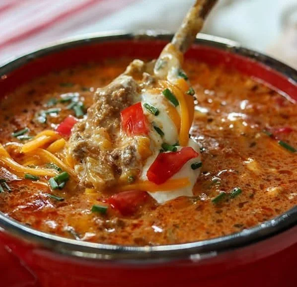 Creamy beef taco soup in a bowl, garnished with cheese and cilantro