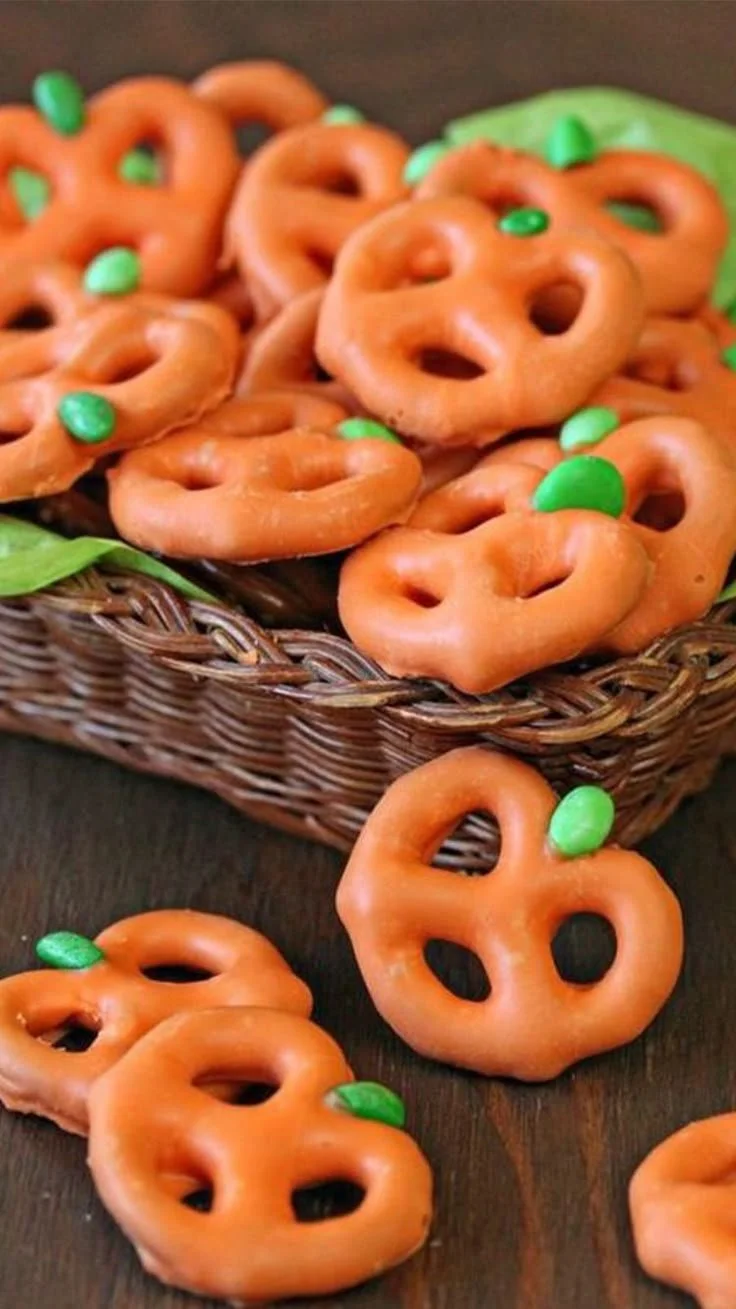 Plate of colorful healthy Halloween snacks, including fruits and veggies shaped like ghosts.