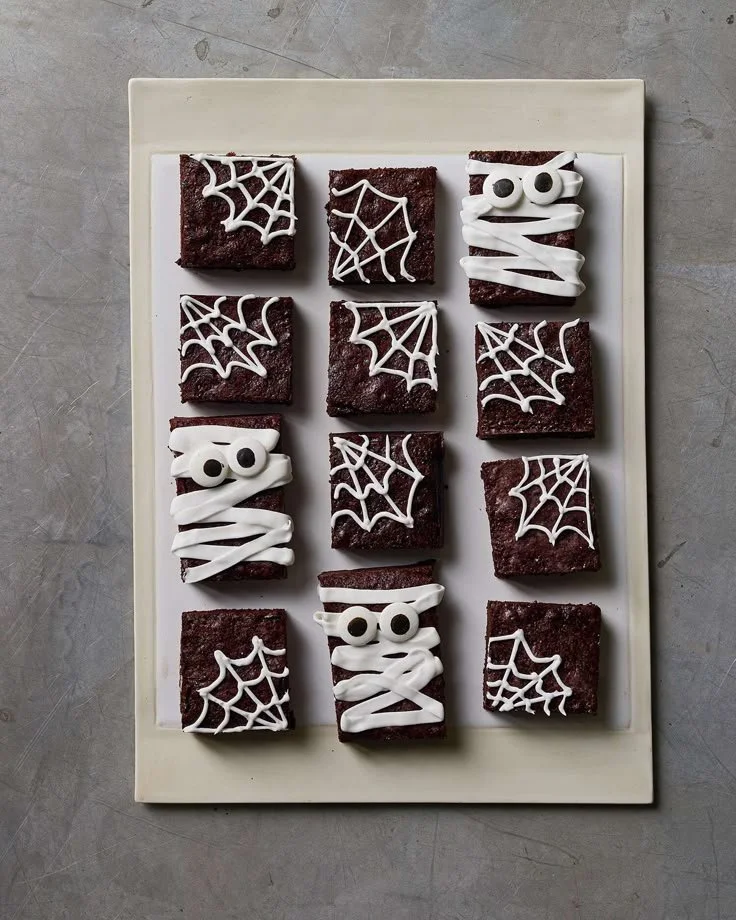 Decorative Halloween snacks arranged on a spooky-themed table for a party