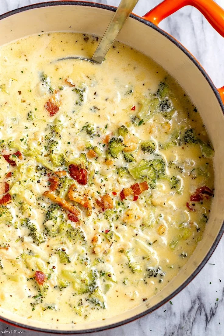 Homemade broccoli cauliflower soup served in a bowl with fresh herbs