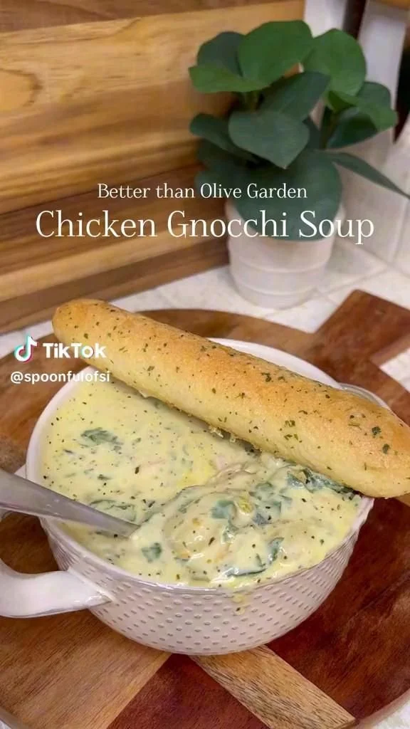 Bowl of creamy chicken gnocchi soup with vegetables and herbs