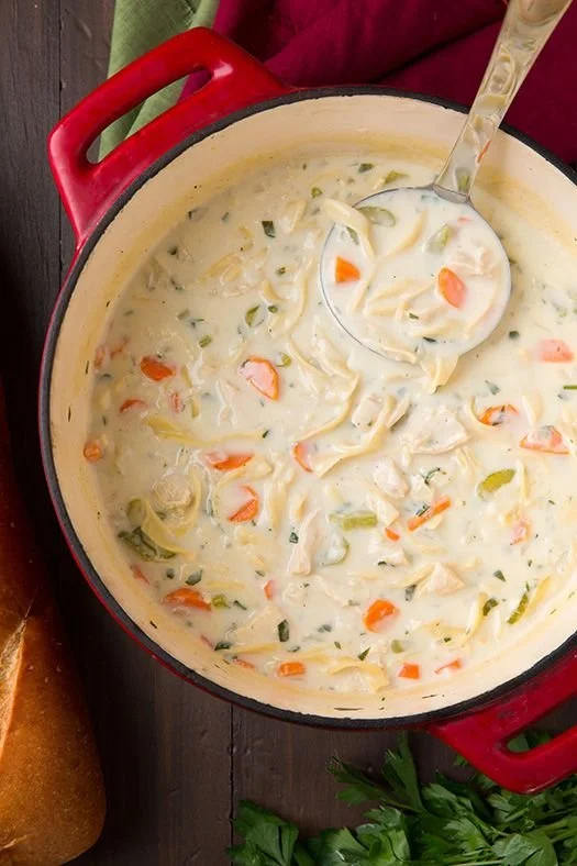 Delicious creamy chicken noodle soup in a bowl with fresh herbs