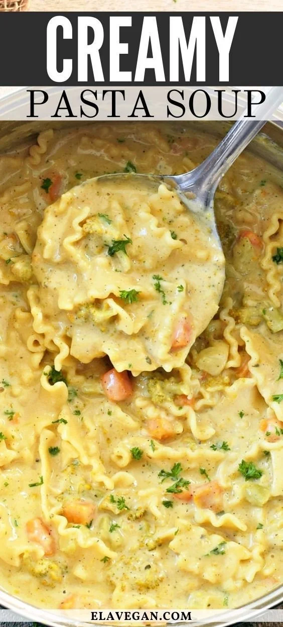 Creamy pasta soup with vegetables and herbs in a bowl
