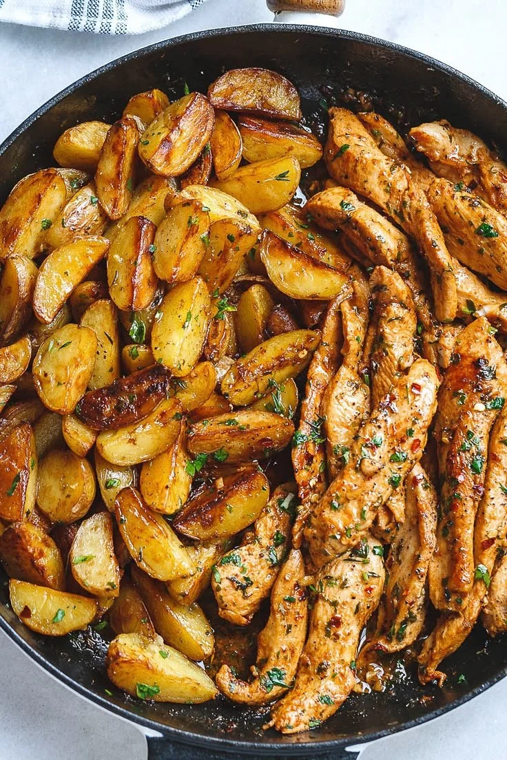 Plate of garlic butter chicken and potatoes, garnished with herbs