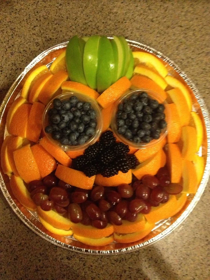 Halloween fruit tray with a pumpkin shaped fruit plate for festive parties