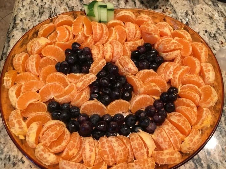 Halloween fruit tray featuring an orange and black berry platter with celery