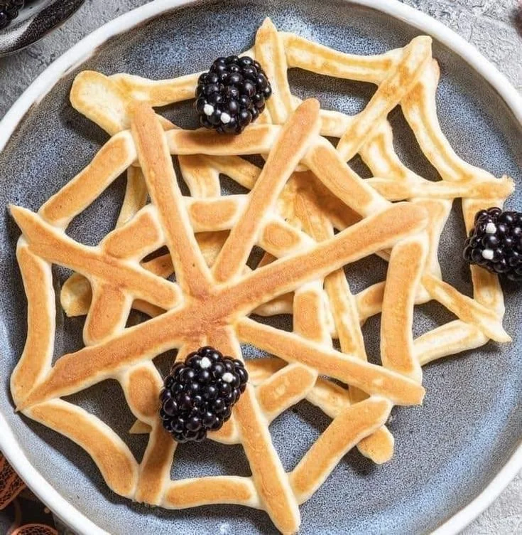 Delicious pancake spaghetti with spider web design for Halloween breakfast.