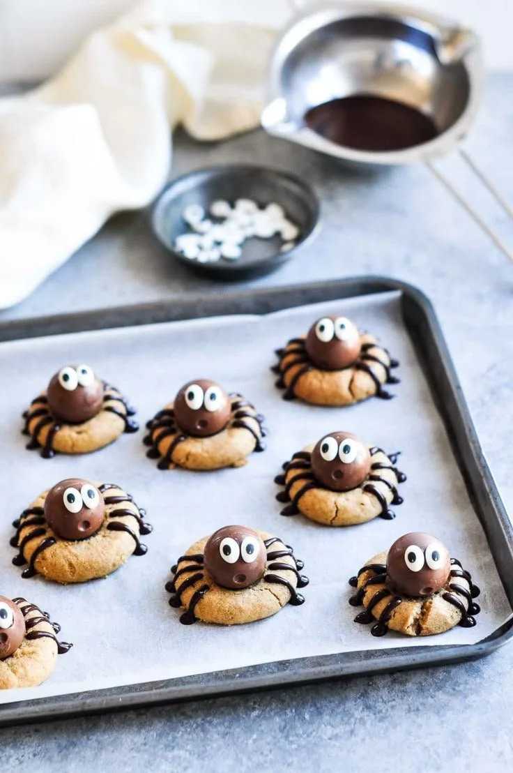 Peanut Butter Spider Cookies on a plate, decorated with chocolate and pretzel legs.