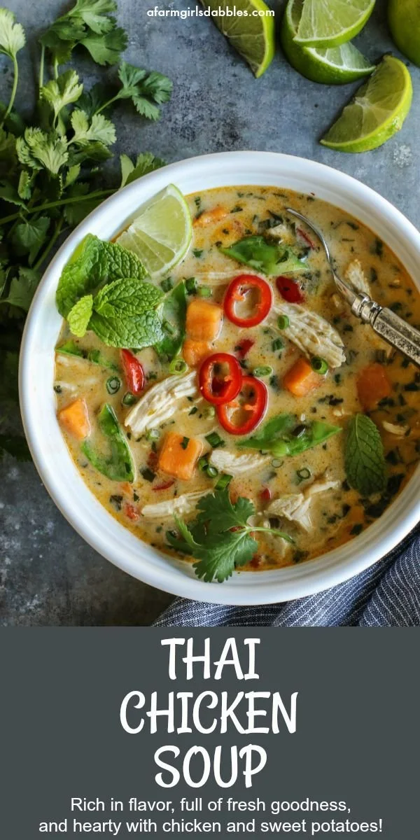 A bowl of Thai chicken soup with sweet potatoes and coconut milk, garnished with herbs.