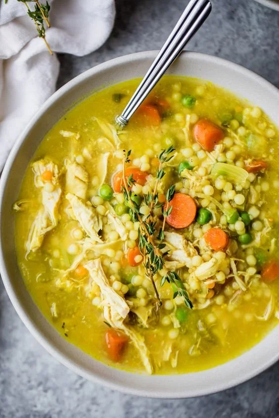 Delicious bowl of homemade chicken soup with vegetables and herbs